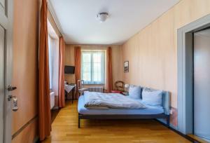 a bedroom with a blue bed in a room at Gasthof Gyrenbad in Turbenthal