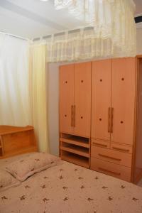 1 dormitorio con 1 cama y armarios de madera en Kd Apartments Mediterranean Village, en Kampala