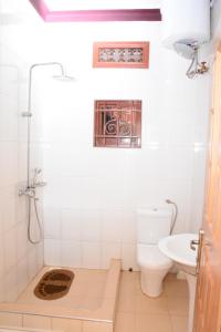 y baño con aseo y lavamanos. en Kd Apartments Mediterranean Village, en Kampala