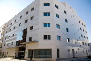 un edificio blanco con ventanas laterales en Hotel Veracruz Plaza & Spa, en Valdepeñas