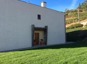 a white building with a door in a yard at Casa no Douro in Mesão Frio