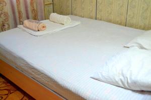a bed with two towels on top of it at Osh Guesthouse in Osh