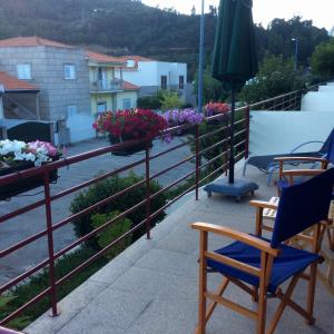 eine Terrasse mit Stühlen und Blumen auf dem Balkon in der Unterkunft Casa no Douro in Mesão Frio