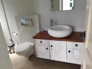 a bathroom with a white sink and a toilet at Heaven@Hermanus in Hermanus