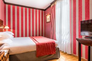 a hotel room with a bed and a television at Villa Panthéon in Paris