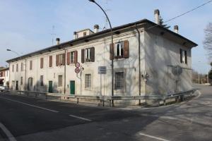an old white building on the side of a street at B&B La Dogana in Forlì