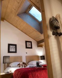 a bedroom with two beds and a skylight at CGH Résidences & Spas Les Chalets d'Angèle in Châtel