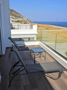 a pair of chairs on a balcony with a view of the ocean at Previllage RED Apartment in Kardamaina