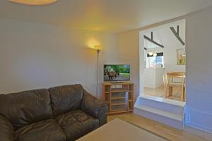 a living room with a couch and a television at Strandens Apartment in Ishøj