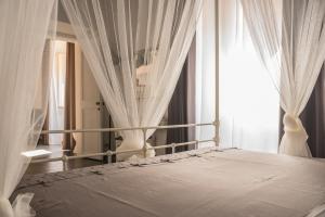 a bedroom with a bed with white curtains and a window at Pantheon116 in Rome