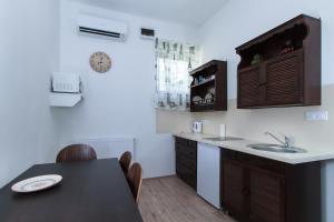 a kitchen with a sink and a table with chairs at Ecoappartment 2 in Mosonmagyaróvár