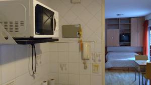 una cocina con microondas y una habitación con 1 cama en Malabia Botanico en Buenos Aires