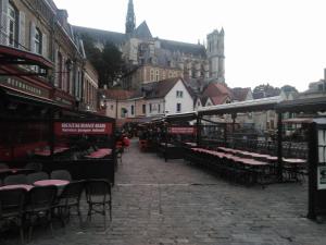 eine Straße mit Tischen und Stühlen in einer Stadt in der Unterkunft Chez Vincent in Amiens