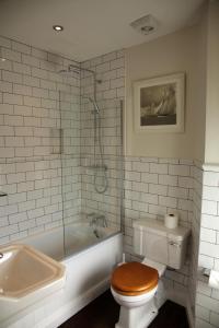 a bathroom with a toilet and a tub and a sink at The Erskine Arms in Conwy