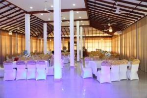 a banquet hall with white and purple tables and chairs at Aarya hotel in Pinnawala +29 photos