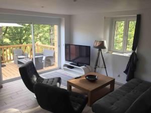 a living room with a couch and chairs and a television at Au Coeur De Lolhm in Le Buisson de Cadouin