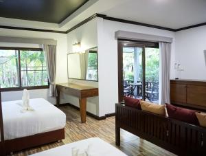 a hotel room with a bed and a desk at Lamai Inn 99 Bungalows in Lamai