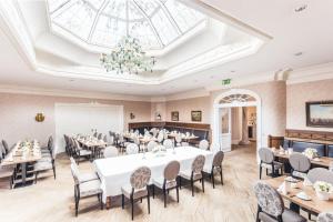 a dining room with tables and chairs and a skylight at Burghotel Haselünne in Haselünne