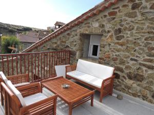 a patio with a table and chairs on a balcony at Casa Sierra de Gredos in Navasequilla