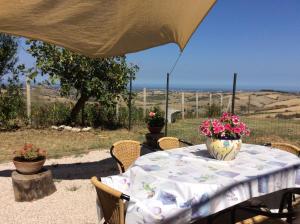 una mesa con un jarrón de flores. en I Rondoni B&B, en San Clemente