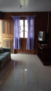 a living room with a couch and a window at Morada das Pedras Recanto da Paz in Piçarras