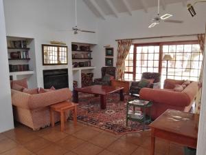 a living room with couches and a fireplace at Nooitgedacht Trout Lodge in Lydenburg