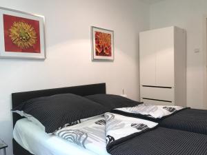Un dormitorio con una cama con almohadas blancas y negras. en Travel Apartments, en Münster