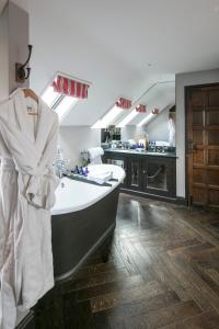 a bathroom with a bath tub and a kitchen at The Kingham Plough in Kingham