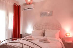 Meteora View Modern Apartments في كالامباكا: غرفة نوم بسرير ابيض عليها منشفتين