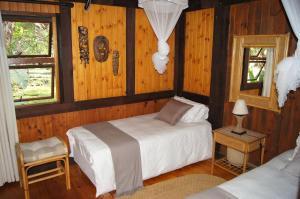 a bedroom with two beds in a room with wooden walls at House 23 Ezulwini in Sodwana Bay Lodge in Sodwana Bay +39 photos