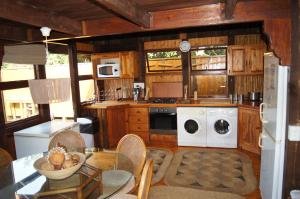 a kitchen with wooden cabinets and a white washer and dryer at House 23 Ezulwini in Sodwana Bay Lodge in Sodwana Bay
