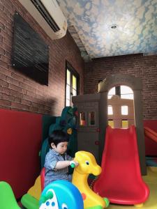 een jonge jongen die speelt op een speelplaats met een glijbaan bij Venetian Signature PoolView Resort Jomtian Pattaya in Jomtien Beach