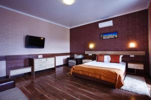 a bedroom with a bed and a flat screen tv at Park Hotel in Kharkiv