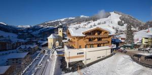 budynek na szczycie pokrytej śniegiem góry w obiekcie Bolodges Apartments by Alpin Rentals w Saalbach Hinterglemm