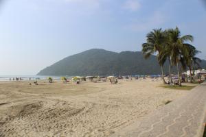 a group of people on the beach with umbrellas at Pousada Flor de Aurora Bertioga in Bertioga