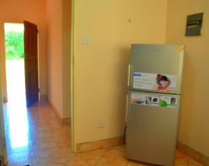 - un réfrigérateur en argent dans une chambre avec couloir dans l'établissement Tinotenda Cottage, à Harare