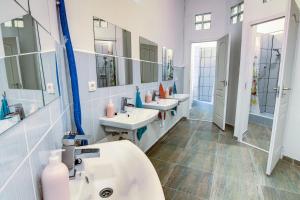 a bathroom with three sinks and two mirrors at Pal's Mini Hostel in Budapest
