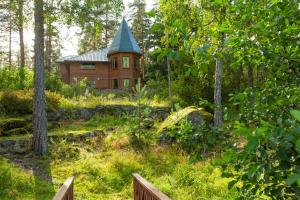 Holiday Park Lesnaya Skazka في فيبورغ: منزل خشبي في وسط غابة