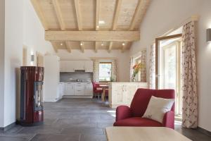 eine Küche und ein Wohnzimmer mit einem roten Stuhl in der Unterkunft Alpenresidenz Ötztal in Oetz