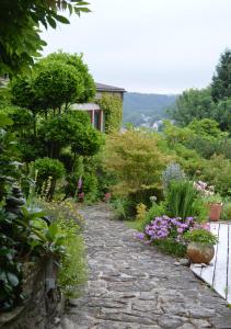 un chemin en pierre dans un jardin fleuri dans l'établissement Jardin de Belle Vue, à Quimperlé