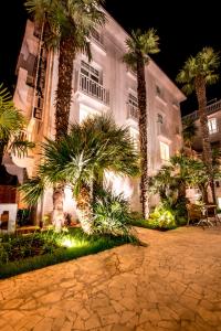 a building with palm trees in front of it at La Palmeraie in La Baule