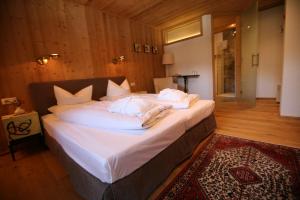 a bedroom with a large bed with white sheets and pillows at Bio-Hotel Saladina in Gaschurn