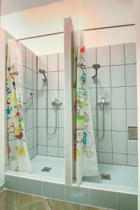 a bathroom with two showers and a shower curtain at Pal's Mini Hostel in Budapest