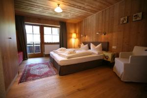 ein Schlafzimmer mit einem großen Bett in einem Zimmer mit Holzwänden in der Unterkunft Bio-Hotel Saladina in Gaschurn