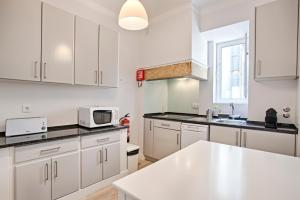 uma cozinha com armários brancos e um balcão branco em BmyGuest - Ambassador Boutique Apartment II em Lisboa