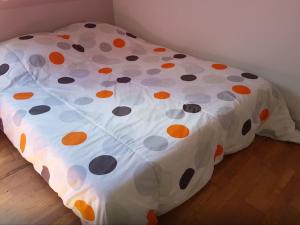 a bed with a polka dot cover on the floor at Gite cosy proche Fontainebleau et foret in Noisy-sur-École