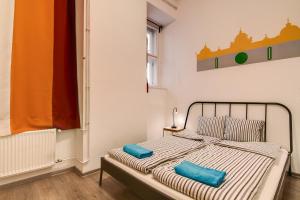 a bedroom with a bed with two blue pillows at Pal's Mini Hostel in Budapest