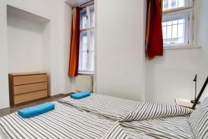 two beds in a room with two windows at Pal's Mini Hostel in Budapest