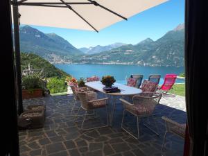 a patio with a table and chairs overlooking a lake at Villa Silvi piscina sauna e hot tub in Perledo