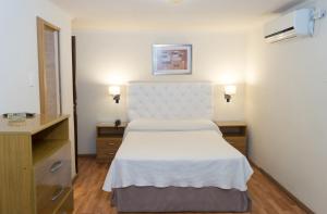a hotel room with a bed and a dresser at Hotel Viña de Italia in Cordoba
